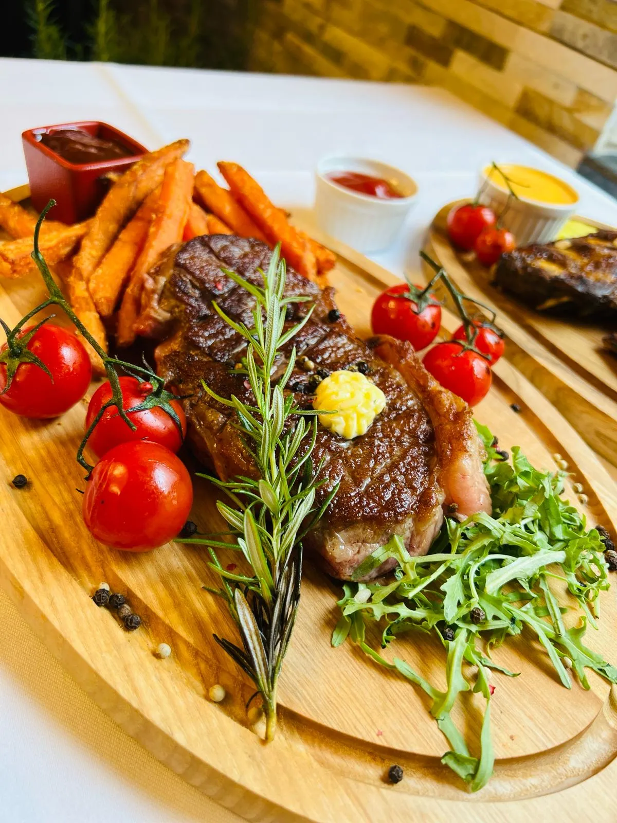 Gegrilltes Rindersteak mit Süßkartoffel-Pommes, Kirschtomaten und Rucola – Ponte Di Rialto Wien